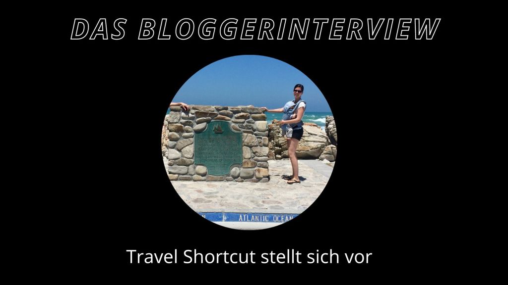 eine frau mit baby in einer bauchtrage an einer mauer