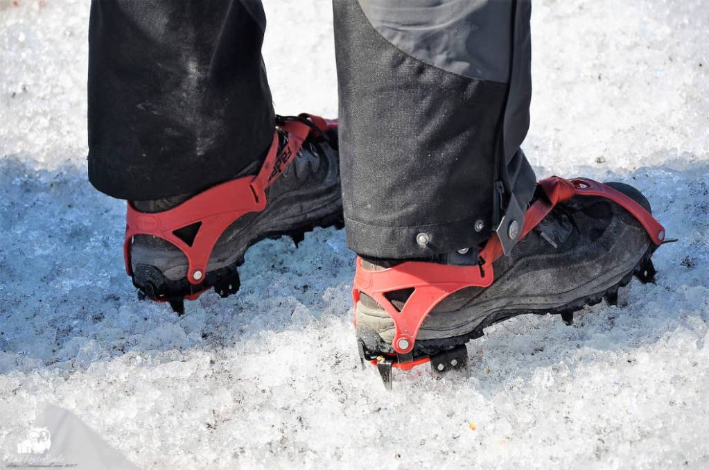 steigeisen an schuhen, person steht auf grönländischem inlandeis