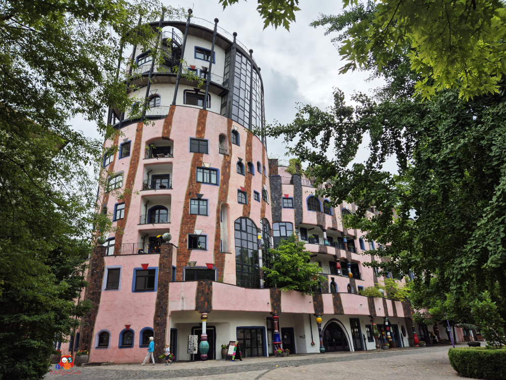 Das Hundertwasserhaus Grüne Zitadelle in Magdeburg, ein farbenfrohes Gebäude mit unregelmäßigen Formen, das Wohnungen, Geschäfte und Cafés beherbergt.