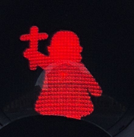 ampelmännchen rot bonifazius hält ein kreuz mit der rechten hand hoch
