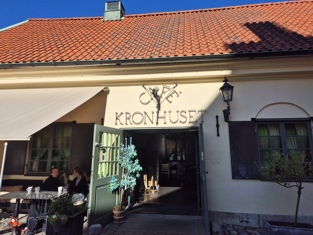 Das historische Gebäude Kronhuset in Göteborg mit einem einladenden Eingangsbereich und Gästen vor dem Café.