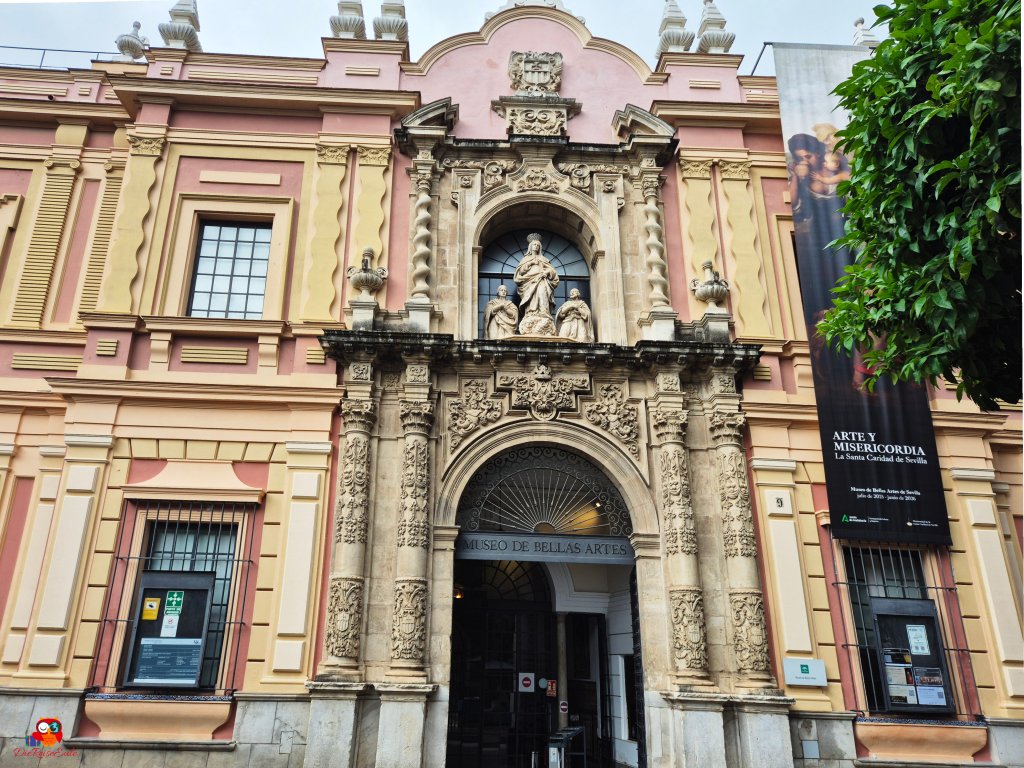 Fassade des Museo de Bellas Artes in Sevilla mit kunstvollen Verzierungen und Statuen über dem Eingang.