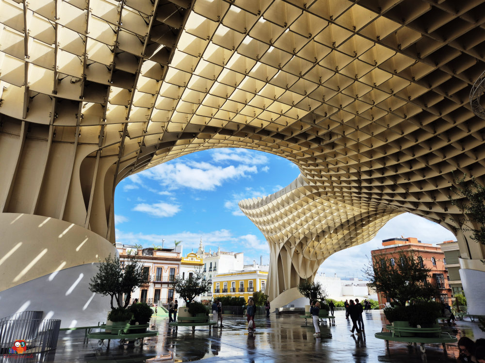 Moderne Architektur der Metropol Parasol in Sevilla, mit einem klaren blauen Himmel im Hintergrund und Besuchern, die die Fläche erkunden.